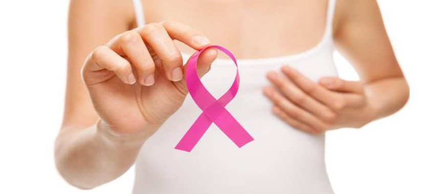 A crossed pink ribbon held by a lady to show the importance of breast cancer awareness