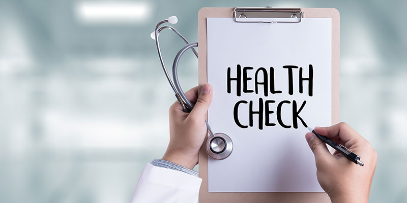A medical professional writes HEALTH CHECK on a notepad illustrating the importance of preventive health check-ups.